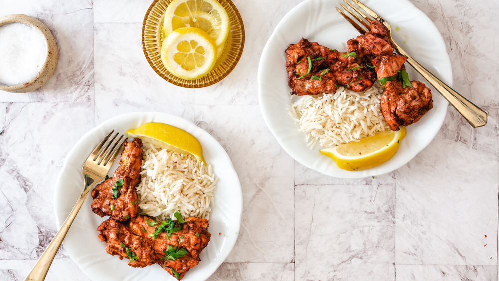 tandoori chicken on plates with lemon slices