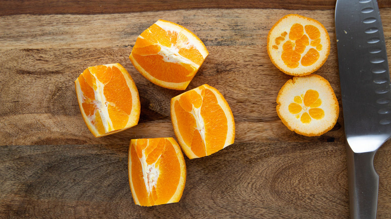 quartered, unpeeled orange with knife