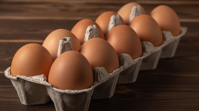 A carton of eggs on a wooden surface