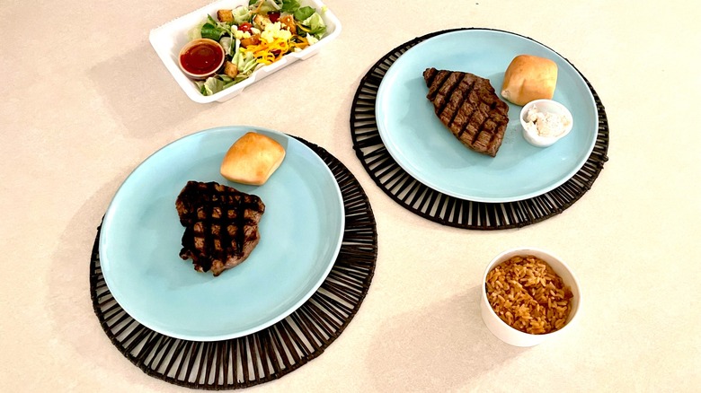 steaks on plates with sides