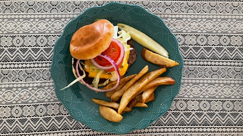 plated cheeseburger pickle and fries