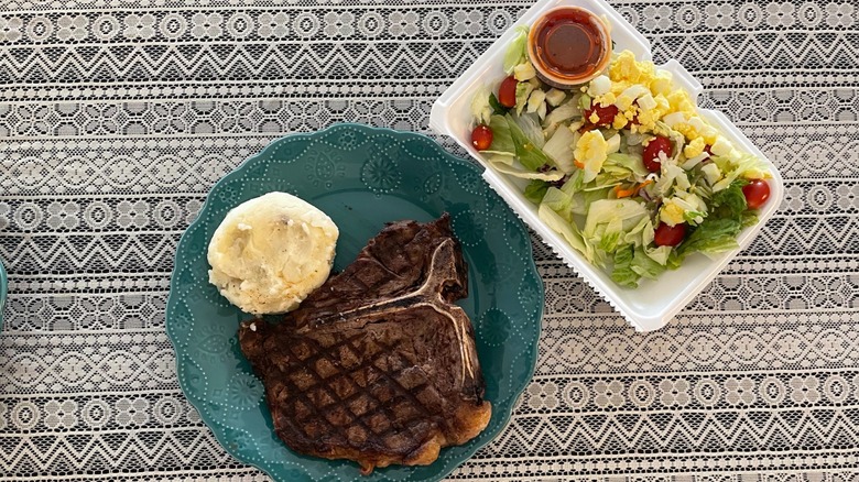 steak and salad on table