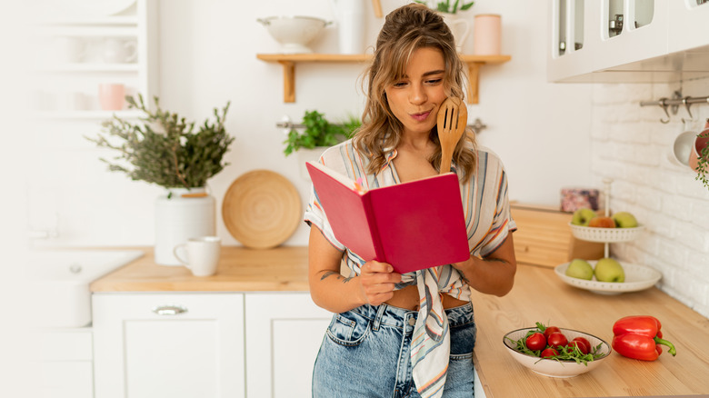 Woman in kitchen with notebook