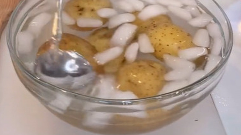 Potatoes in iced water, spoon