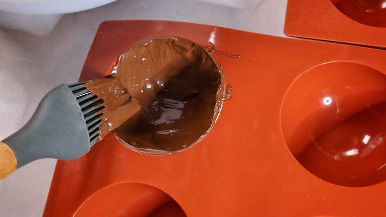 brushing melted chocolate into mold