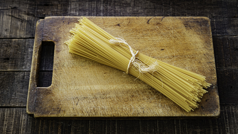 Uncooked spaghetti on cutting board