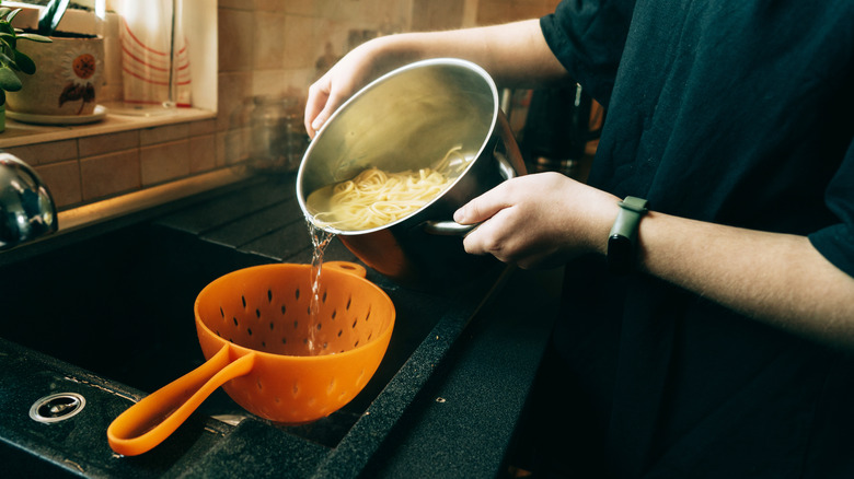 Pouring pasta into colander