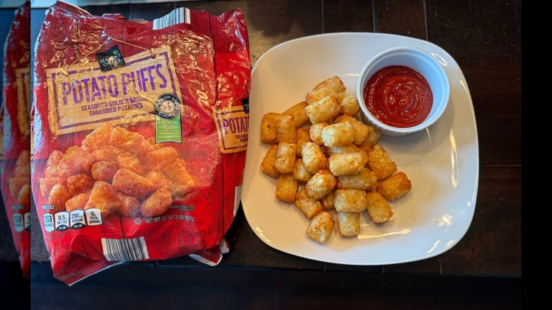 potato puffs on a white plate with ketchup and the package on the left