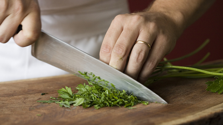 man chopping herbs on board