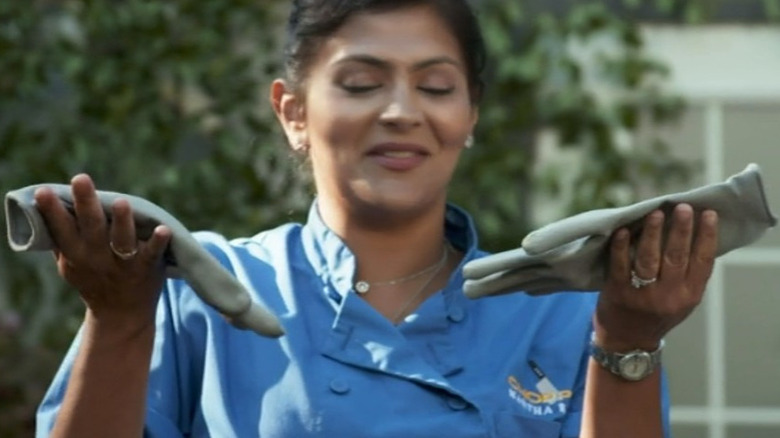 Contestant holding pair of gloves