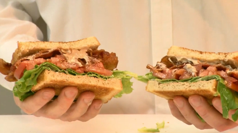 Person holding BBLT sandwich