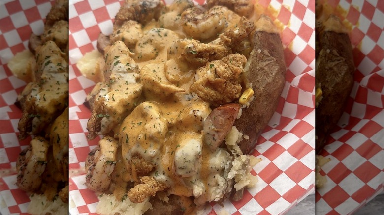 Closeup of loaded baked potato with chicken and shrimp