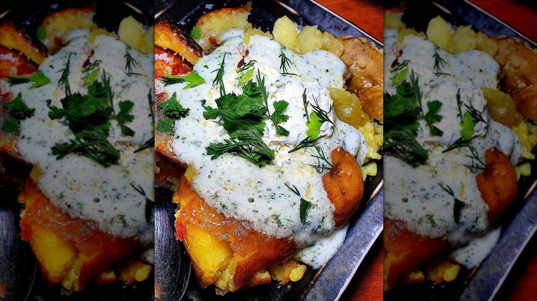 Baked potato with cream and fresh herbs