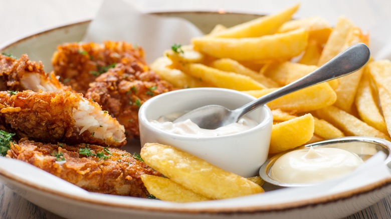 Fried fish and chips with mayo on a plate