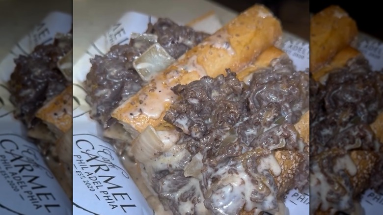 A cheesesteak sits on paper.