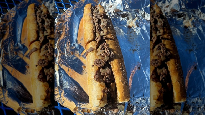 A Philly cheesesteak sits on foil