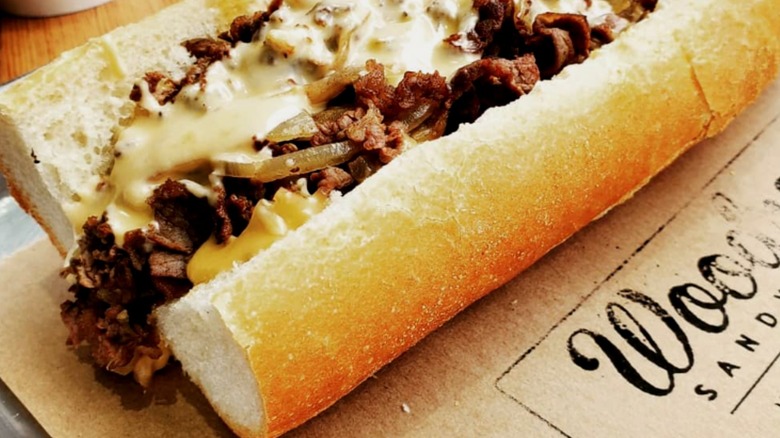 A cheesesteak sandwich sits on paper