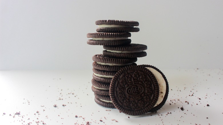 A stack of Oreos surrounded by crumbs