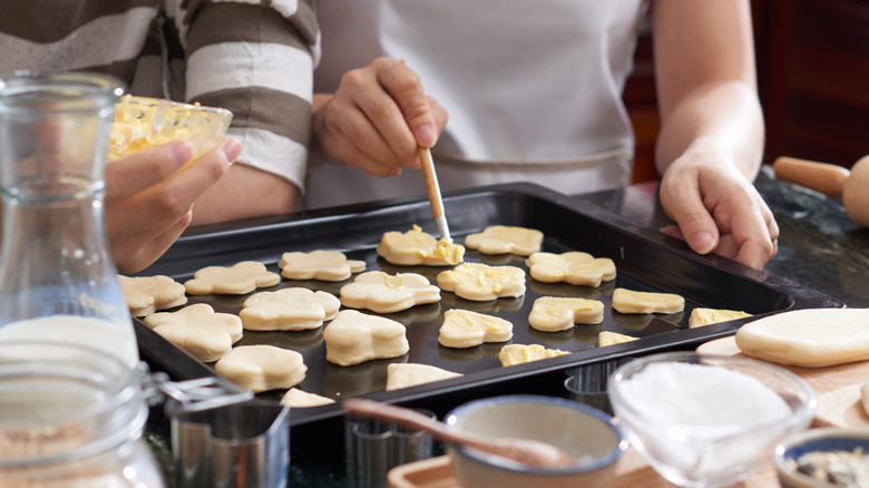 brushing butter on raw cookie dough