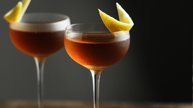 Bourbon cocktail in a coupe glass with a citrus peel