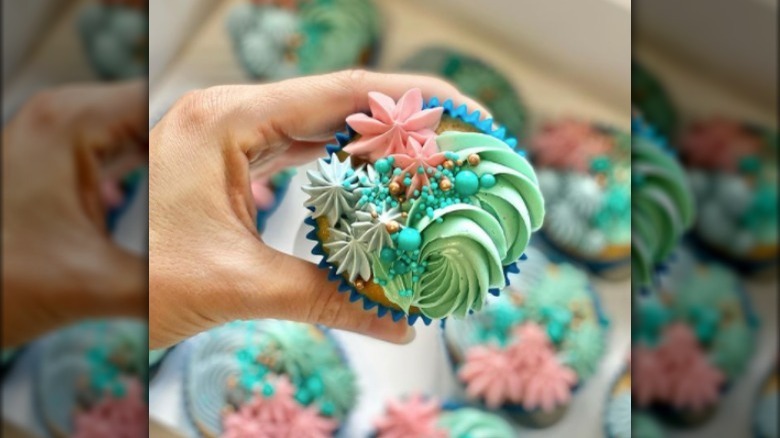 holding a pretty colorful cupcake