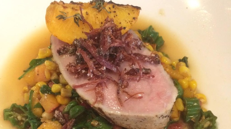 pork tenderloin with succotash on white plate