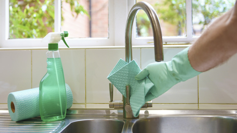 man cleaning kitchen sink