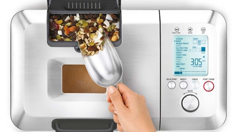 adding fruit and nuts to the reservoir of a Breville bread machine 