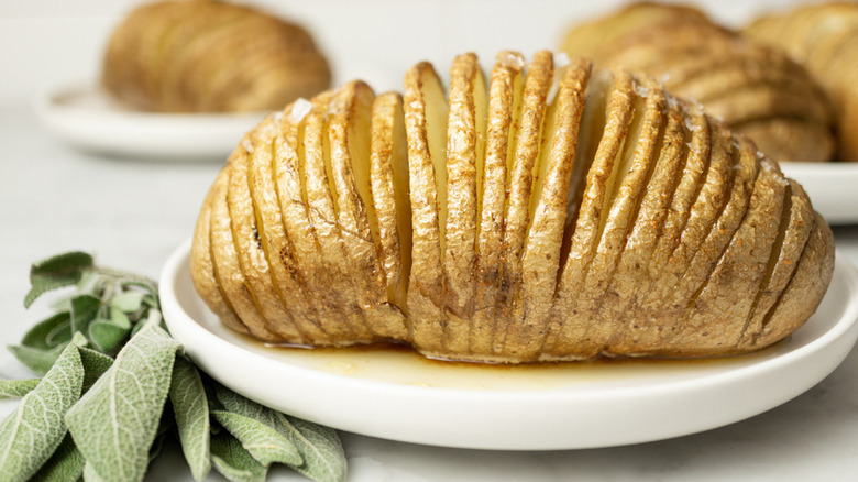 Hasselback potatoes on white plates