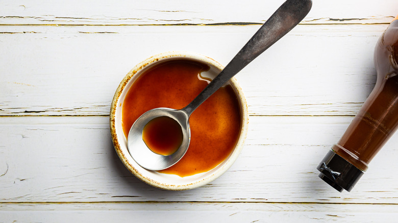 Brown sauce with bottle in bowl