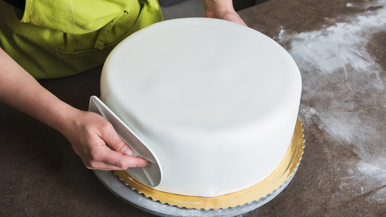 smoothing white fondant cake