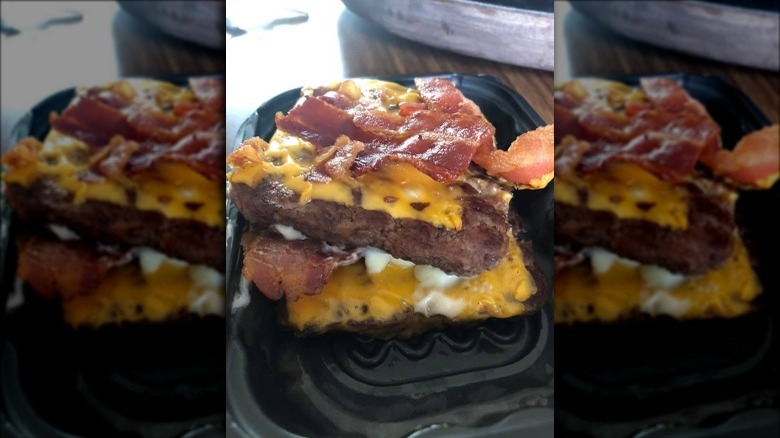 Wendy's Baconator with no bun on wood table