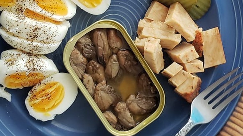 Smoked oysters in a tin with eggs and cheese