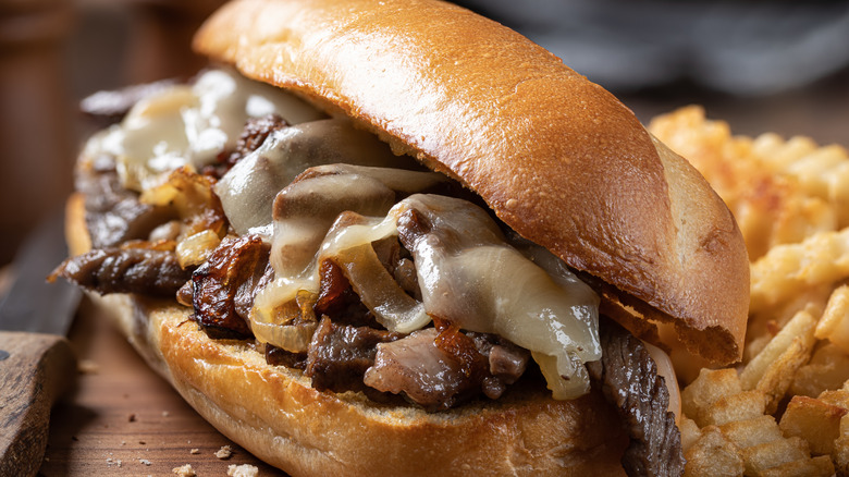 close-up of a Philly cheesesteak sandwich with onions and melted cheese