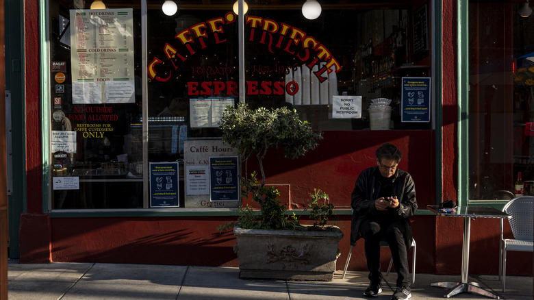 Person sitting in front of Caffe Trieste