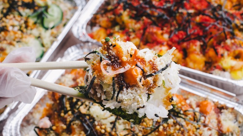 lei'd salmon baked poke with white chopsticks and poke in the background