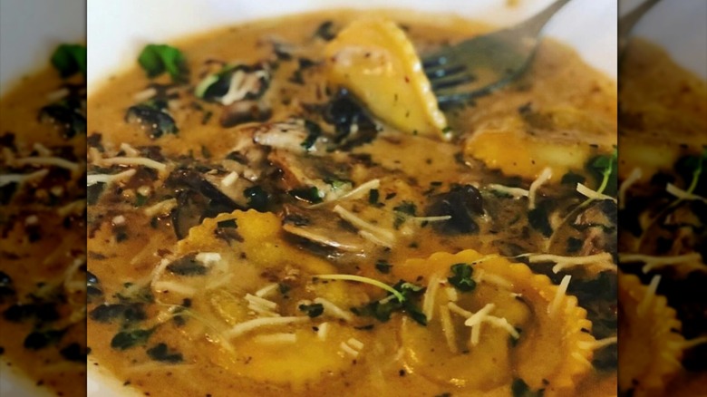 Mushroom ravioli with cheese and herbs and fork