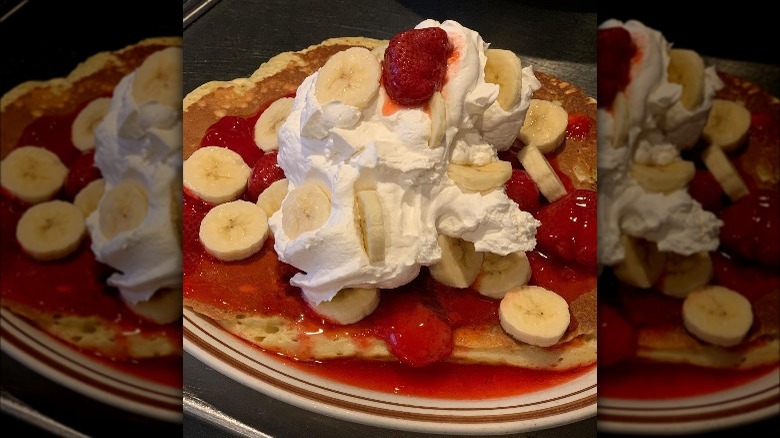 Strawberry banana pancakes topped with whipped cream