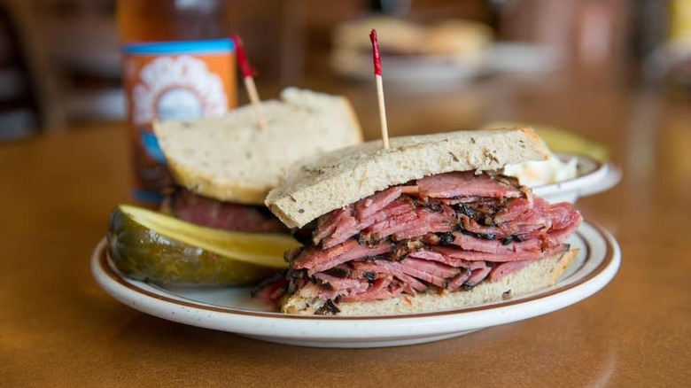 pastrami sandwich and pickle on plate