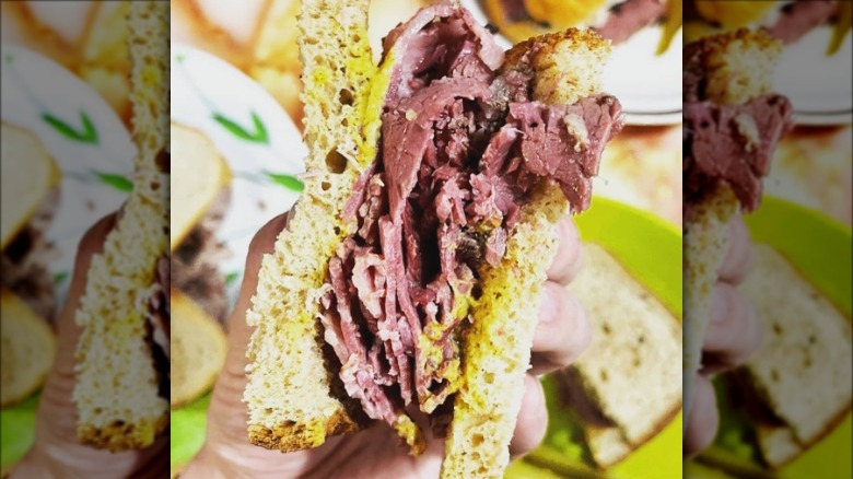 person holding pastrami sandwich