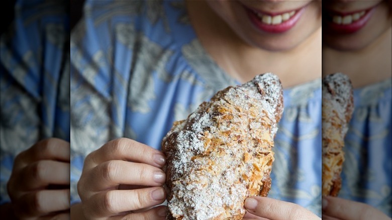 Woman holding twice baked croissant 