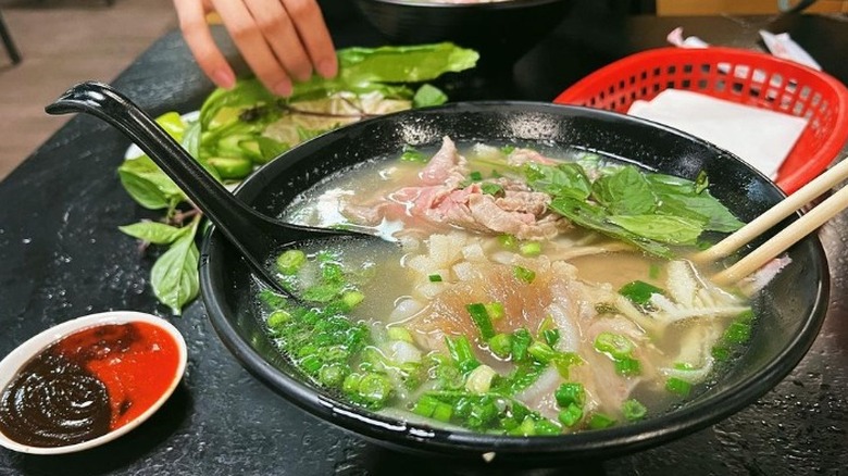 pho in black bowl on black background