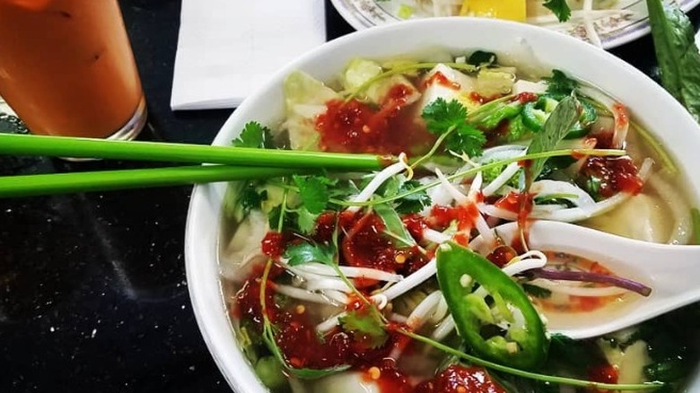 pho with sriracha and green chopsticks