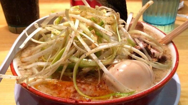 Beans, noodles and egg in red bowl