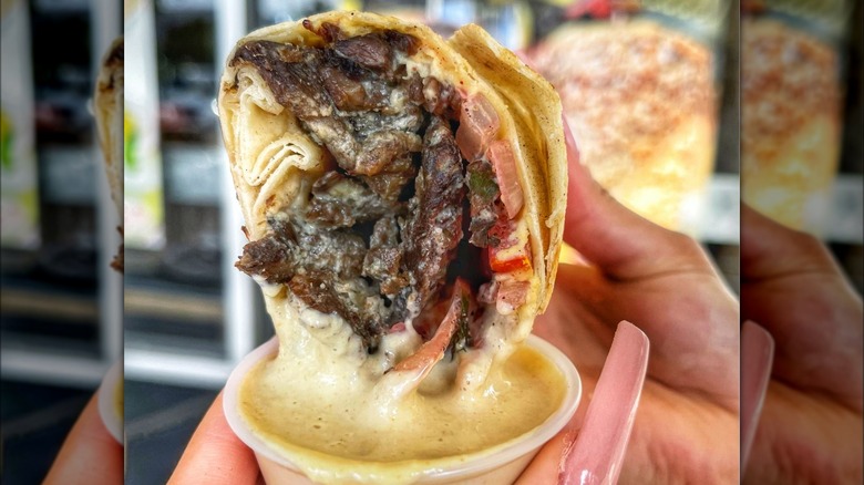 beef shawarma wrap dipped in sauce