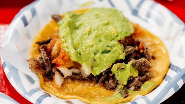 close up of carne asada taco with guacamole