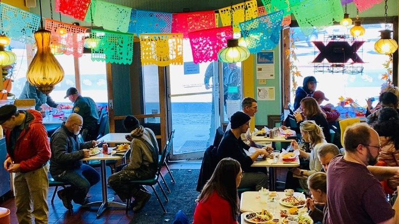 tons of customers eating inside taco trio's packed dining room