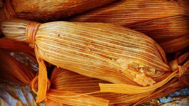 close up of a stack of tamales on foil