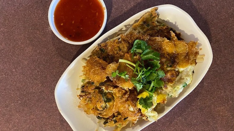 A plate of crispy chicken with a dipping sauce