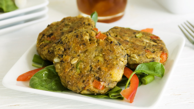 Three homemade veggie burger patties sit on a plate.